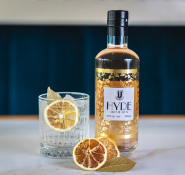Hyde Gin next to a filled tumbler glass with garnish